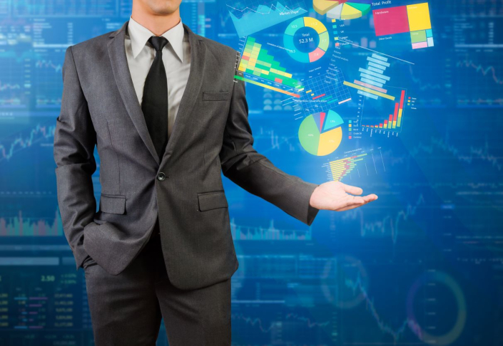 A man in a suit hold out his hand, where projections of various data visualizations hover over his hand.